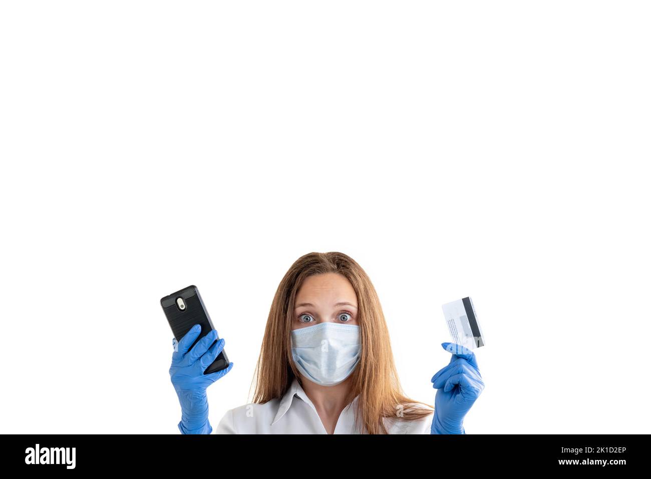 Bankprobleme. Covid-19-Beschränkung. Gesperrtes Konto. Online-Zahler. Schockierte Frau in Schutzmaske Handschuhe halten Kreditkarte und Handy-Look Stockfoto