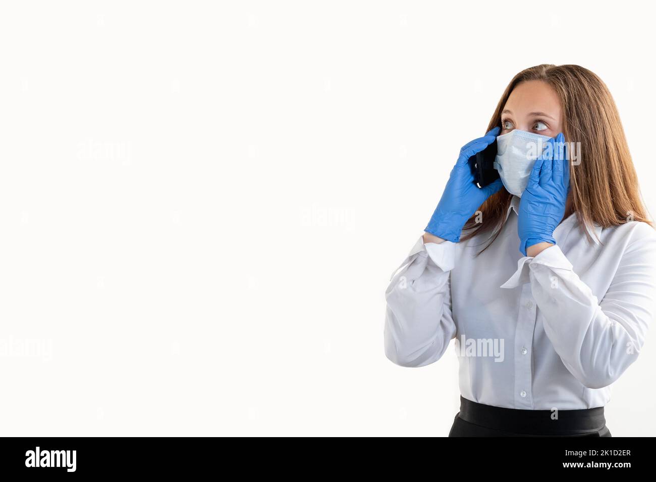 Covid-19-Beschränkung. Geschäftsprobleme. Mobile Kommunikation. Verängstigte Bürofrau in Schutzmaske Handschuhe reden per Telefon suchen Kopie Raum isola Stockfoto