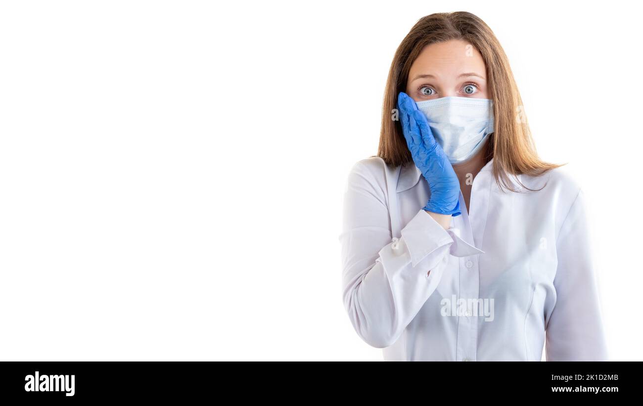 Covid-19 Gefahr. Überraschte Frau. Büroarbeit. Quarantänemaßnahmen. Besorgte Dame in Medizin Maske Handschuhe halten Gesichtshand Blick auf Kamera isoliert Stockfoto