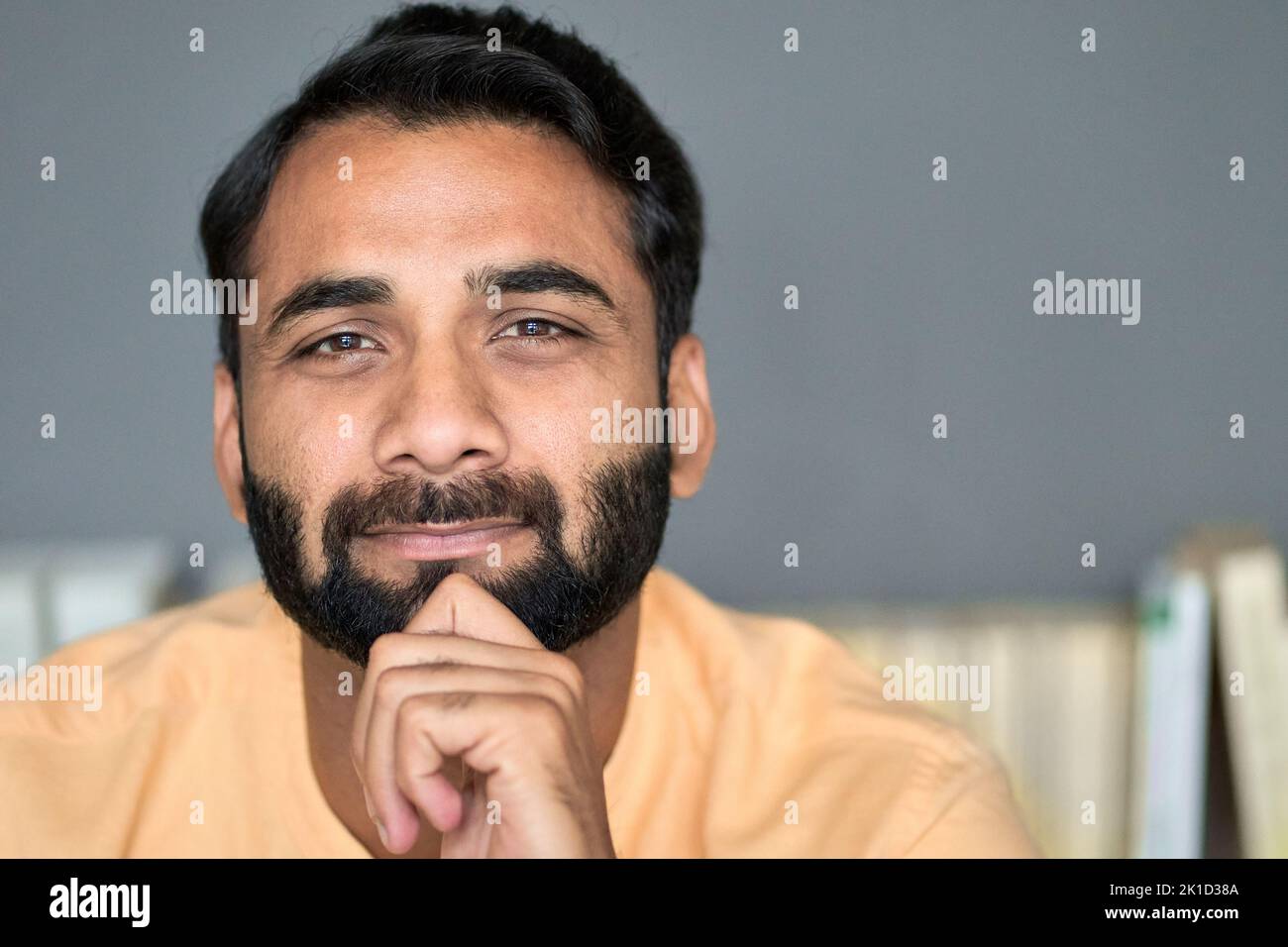 Indischer ethnischer bärtiger Mann, der zuhause die Kamera anschaut. Nahaufnahme im Hochformat. Stockfoto