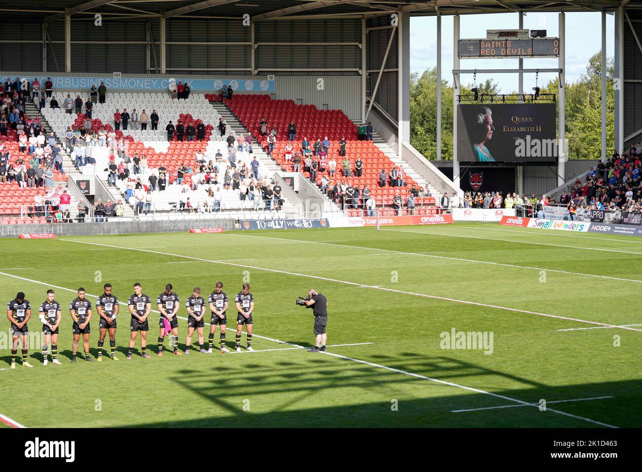 Die Spieler von Salford Red Devils stehen für eine Minute Stille, während auf dem Bildschirm ein Foto von Königin Elizabeth II vor dem Betfred Super League-Spiel St Helens gegen Salford Red Devils im Totally Wicked Stadium, St Helens, Großbritannien, 17.. September 2022 (Foto by Steve Flynn/News Images) Stockfoto