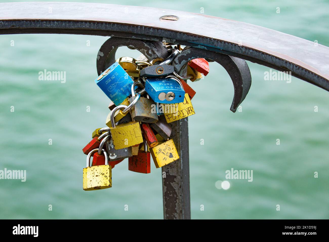 Viele Vorhängeschlösser auf einem Geländer am Wasser als Symbol der Liebe. Stockfoto