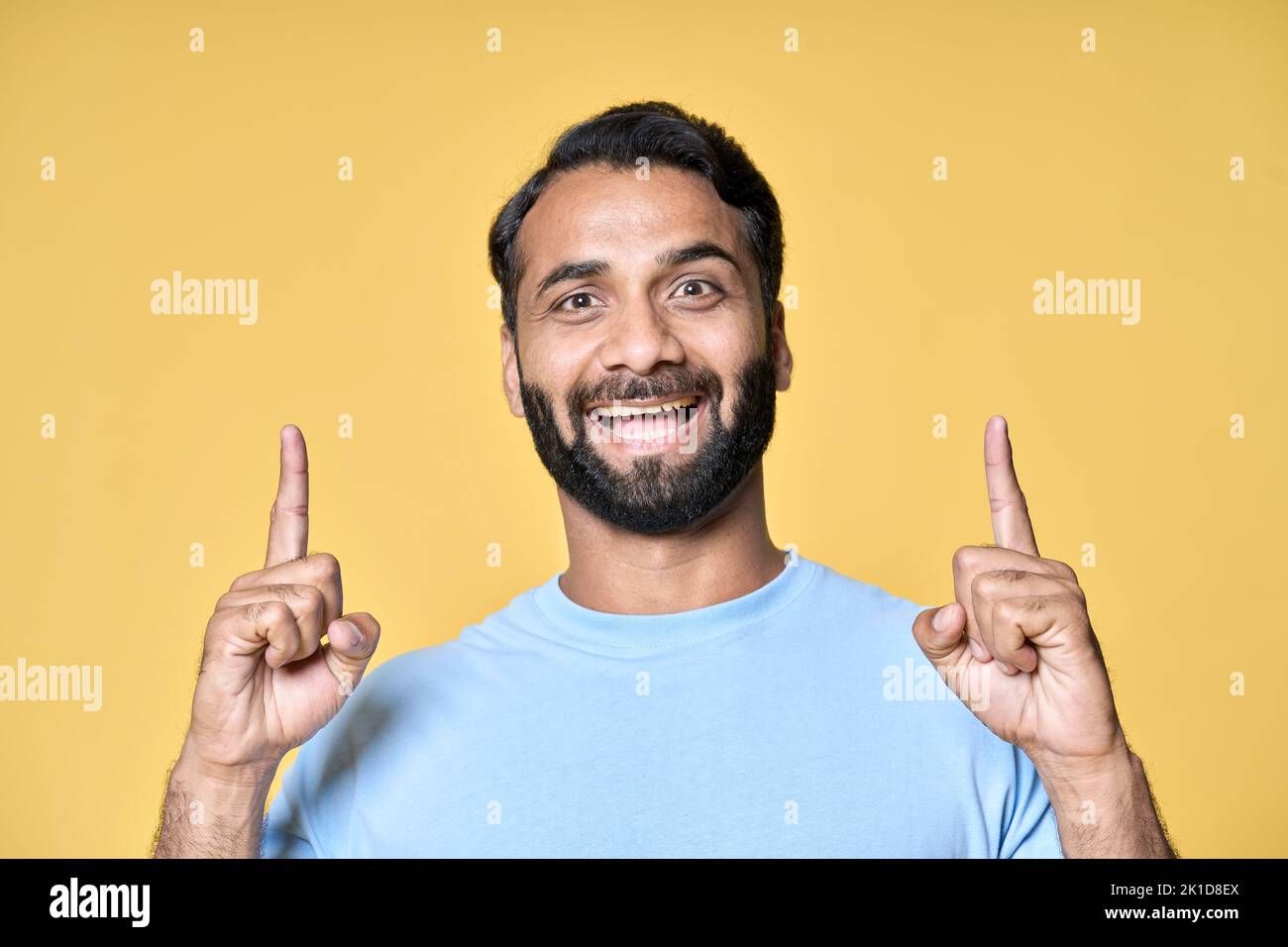 Aufgeregt indischen Mann zeigt Werbung E-Commerce-Angebot isoliert auf gelb. Stockfoto