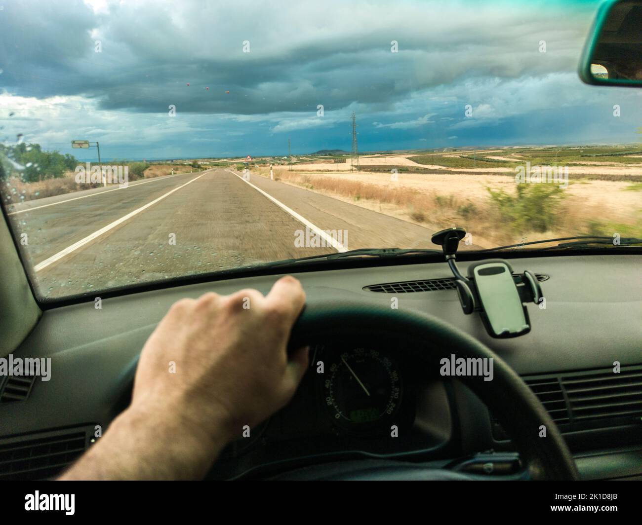 Fahrt unter dem stürmischen Himmel bei Sonnenuntergang. Blick von innen Stockfoto
