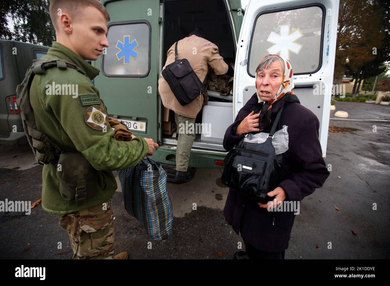 KOZACHA LOPAN, UKRAINE - 16. SEPTEMBER 2022 - Eine Frau steht in der Nähe einer Nationalgarde, die bei der Evakuierung von Anwohnern in die region hilft Stockfoto