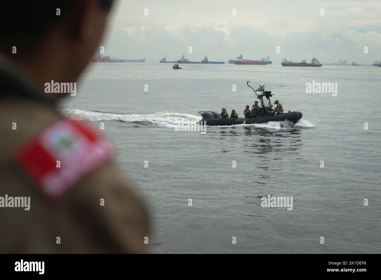 Ein peruanisches Militärmitglied beobachtet, wie ein SEAL-Team der US-Marine sich während des Visit, Board, Search, and beschlagnahmt (VBSS)-Trainings mit Partnerländern während der UNITAS LXIII-Übung in Rio de Janeiro, 15. September 2022, auf ein Schiff vorbereitet. UNITAS ist die am längsten laufende internationale maritime Übung der Welt, die sich auf die Verbesserung der Interoperabilität zwischen mehreren Nationen und gemeinsamen Kräften während Litoral- und Amphibienoperationen konzentriert, um auf bestehenden regionalen Partnerschaften aufzubauen und neue dauerhafte Beziehungen zu schaffen, die Frieden, Stabilität und Wohlstand im A des US Southern Command fördern Stockfoto