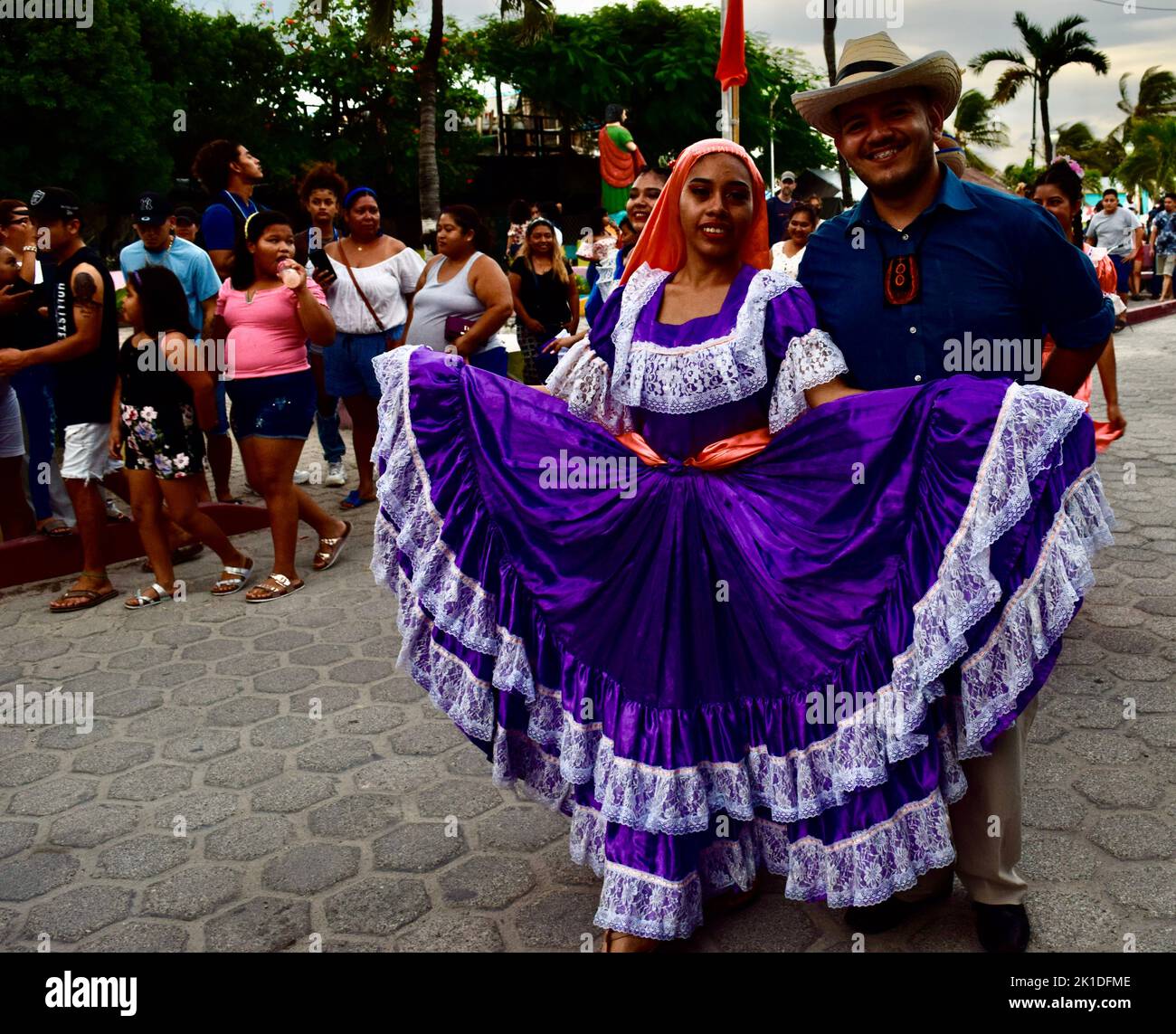 Traditionell gekleidete Männer und Frauen, die in San Pedro, Belize, die Straßen entlang für Noche Centroamericana durchziehen. Stockfoto