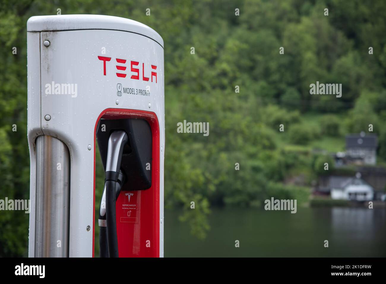 Norheimsund, Norwegen - 13. Juni 2022: Eine statische Aufnahme eines soliden schwarzen Tesla Model 3 Dual Motor, der am Norheimsund Supercharger in einem sonnigen Sproß geladen wird Stockfoto