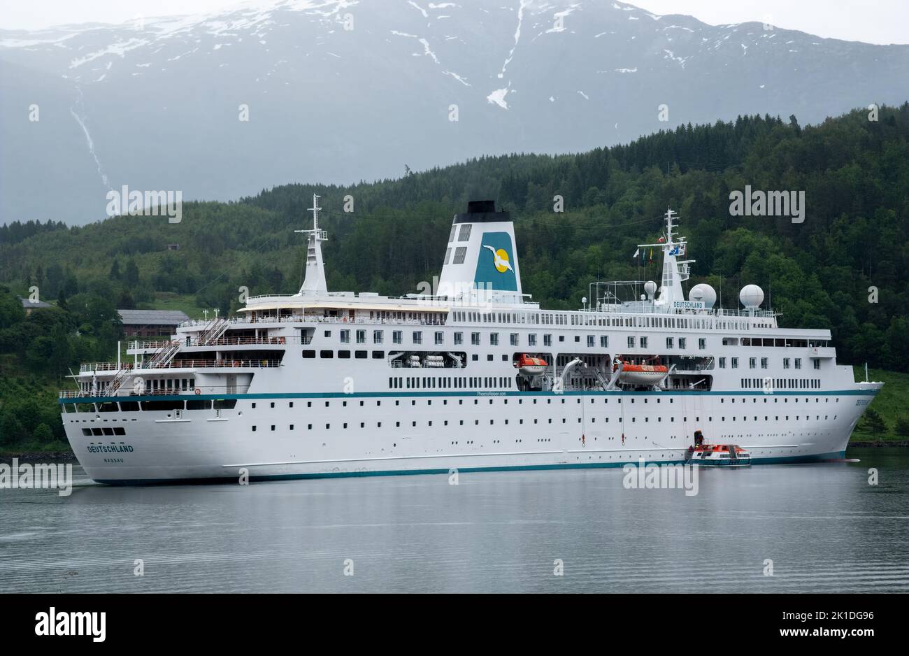 Ulvik, Norwegen - 17. Juni 2022: Ein Phoenix Reisen Kreuzfahrtboot in Schwierigkeiten, Passagiere mit kleinen Booten ans Ufer zu evakuieren. Regentag. Selektiver Fokus Stockfoto