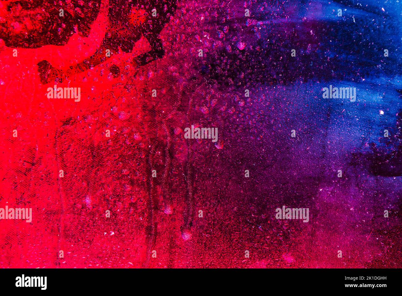 Textur in einem Glas mit Wassertropfen auf farbenfrohem Hintergrund. Stockfoto
