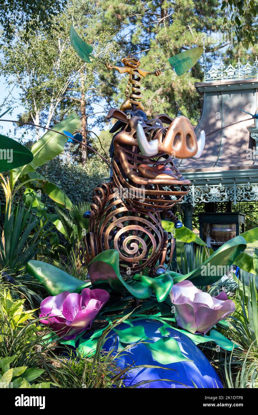 Eine vertikale Aufnahme einer Disney-Zeichentrickfigur Pumbaa-Skulptur in einem Garten in Disneyland, Frankreich Stockfoto
