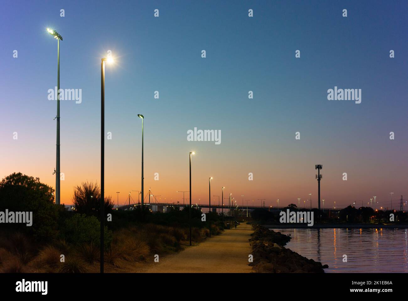 Abenddämmerung durch Port Phillip Bay, Melbourne, mit der Westgate Bridge im Hintergrund. Stockfoto