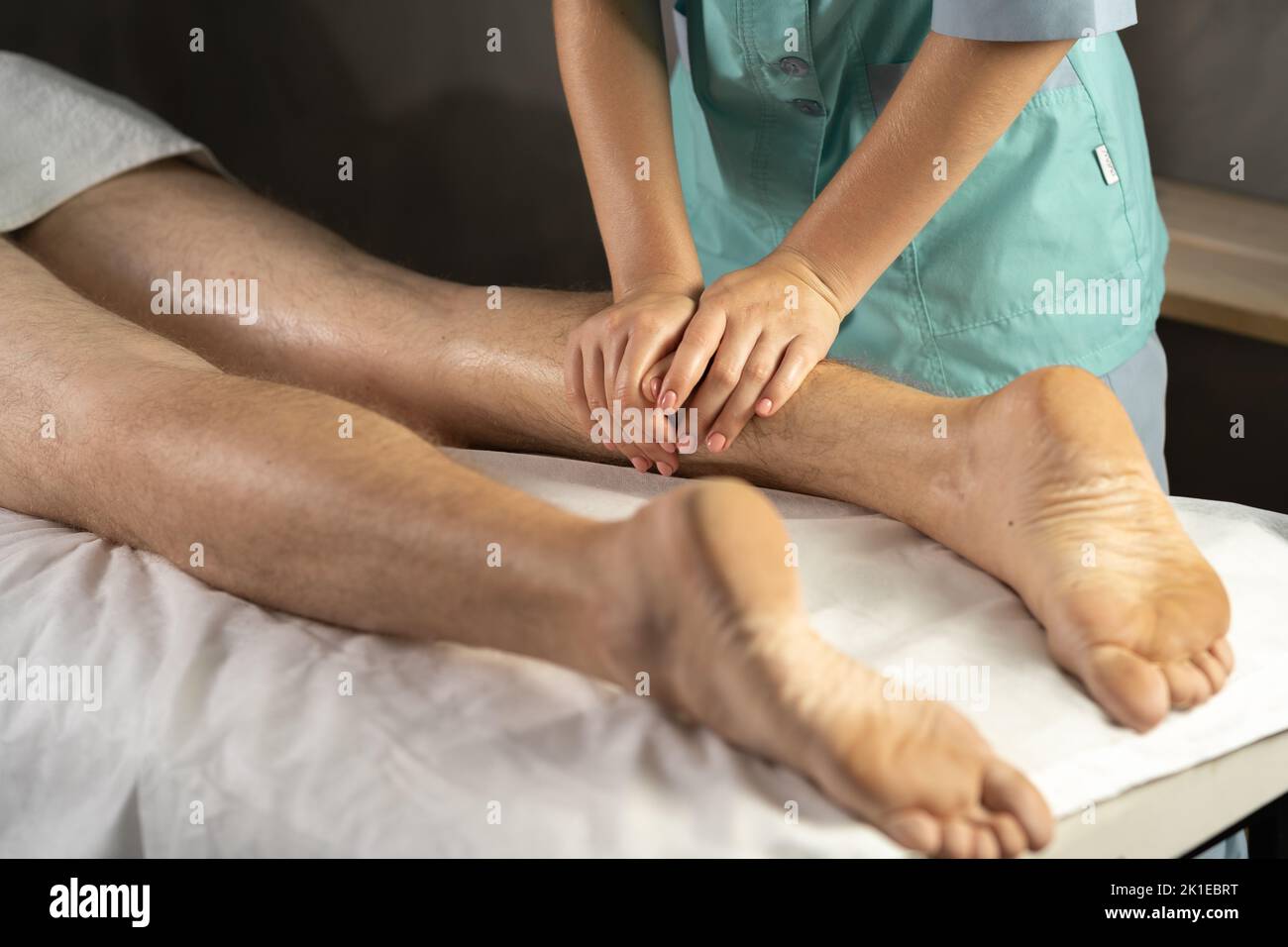 Fußmassage. Physiotherapeut massiert Beine von jungen männlichen Athleten im Spa-Salon Stockfoto