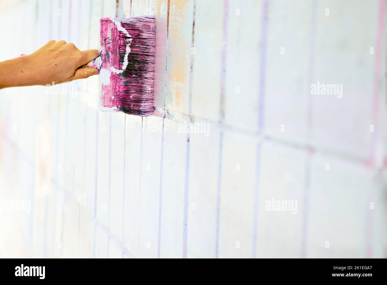 Pinsel Malerei färben Oberfläche der weißen Wand mit rosa magenta lila Farbe Stockfoto