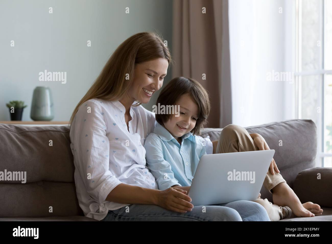 Glückliche hübsche Mutter und neugieriger Sohn Kind beim Film Stockfoto