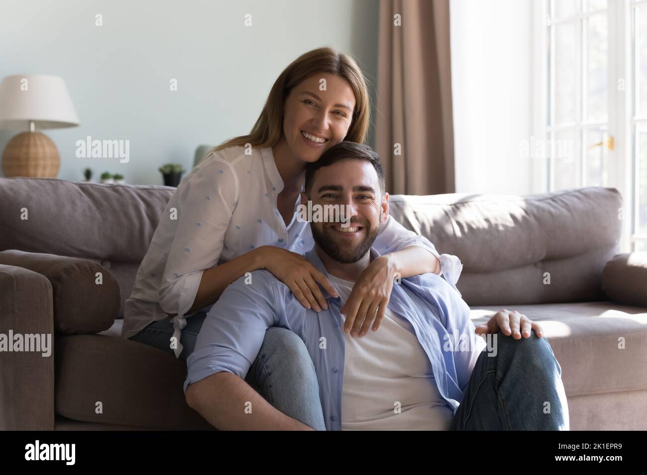 Glücklich attraktive Millennial paar posiert im Wohnzimmer Stockfoto