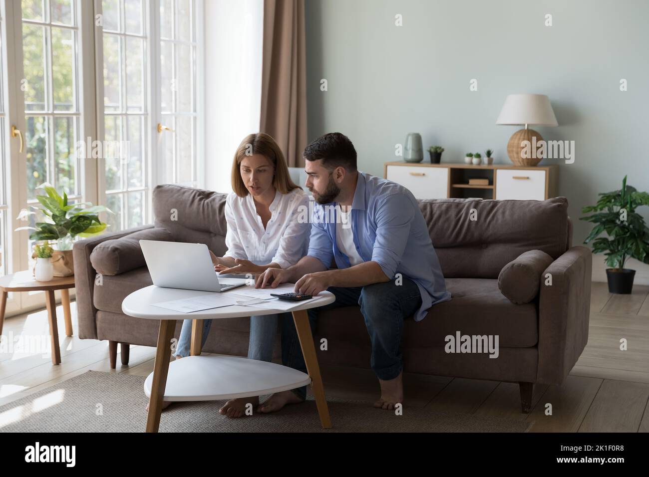 Serious Millennial Ehemann und Ehefrau diskutieren Familienkosten Stockfoto