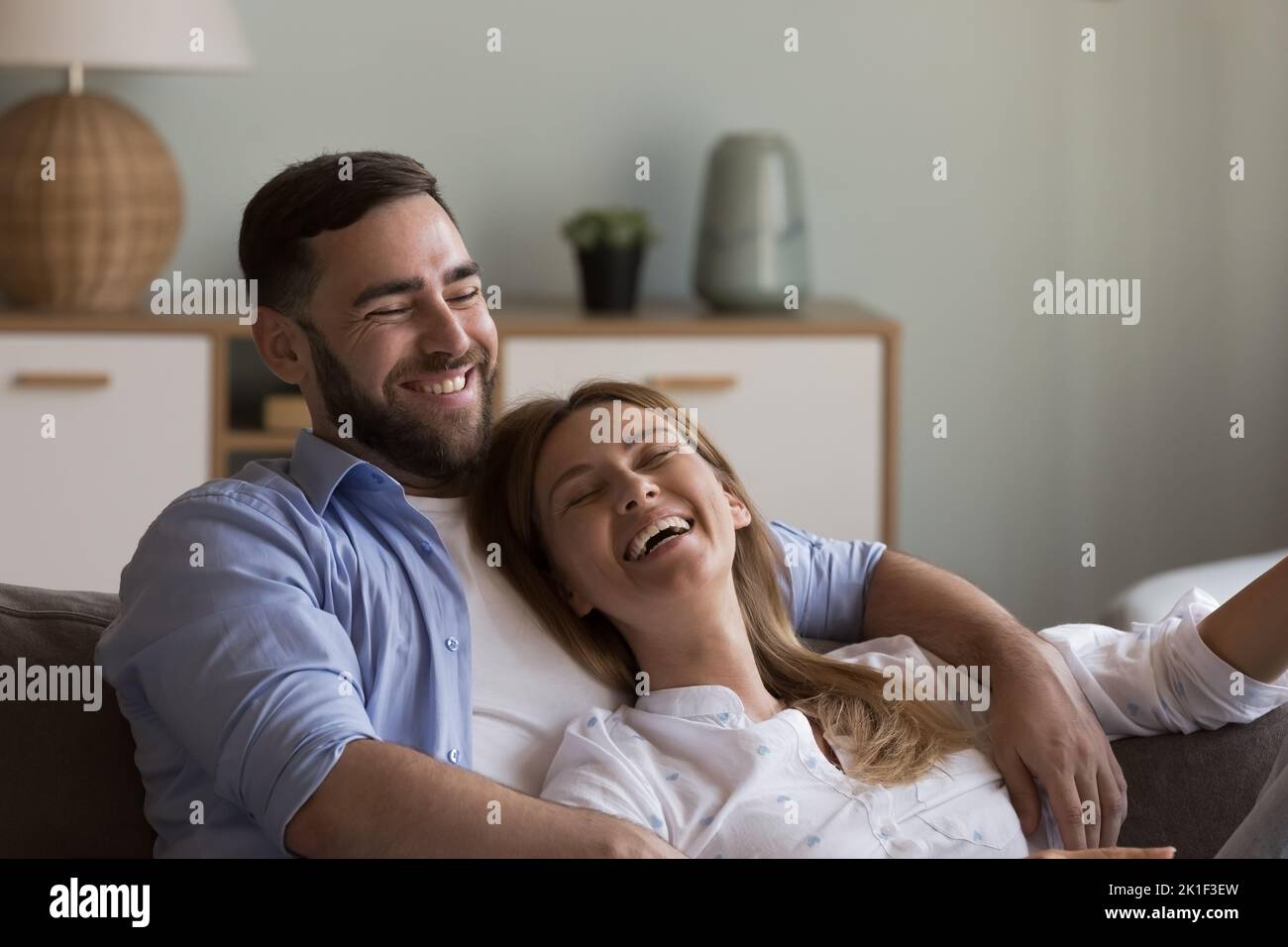 Entspanntes, glückliches Dating-Paar in der Liebe, das sich auf der gemütlichen Couch ausruht Stockfoto