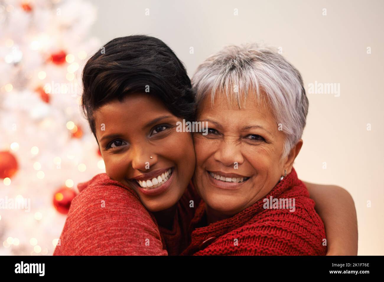 Gute Weihnachtszeit. Eine ältere Frau, die an Weihnachten von ihrer Tochter umarmt wurde. Stockfoto