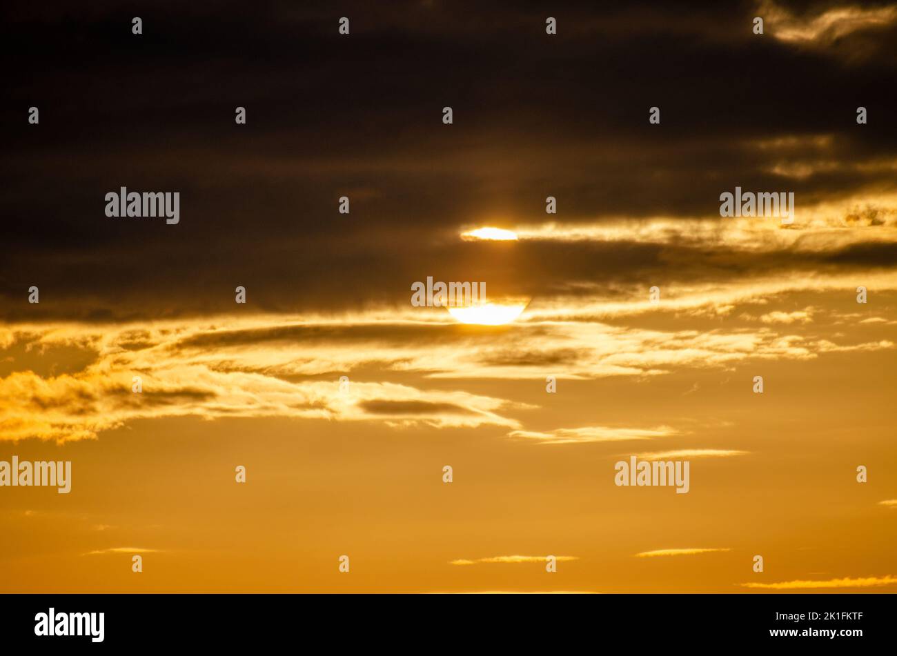 Goldener Sonnenuntergang hinter dunklem Himmel im kalten Norden Stockfoto