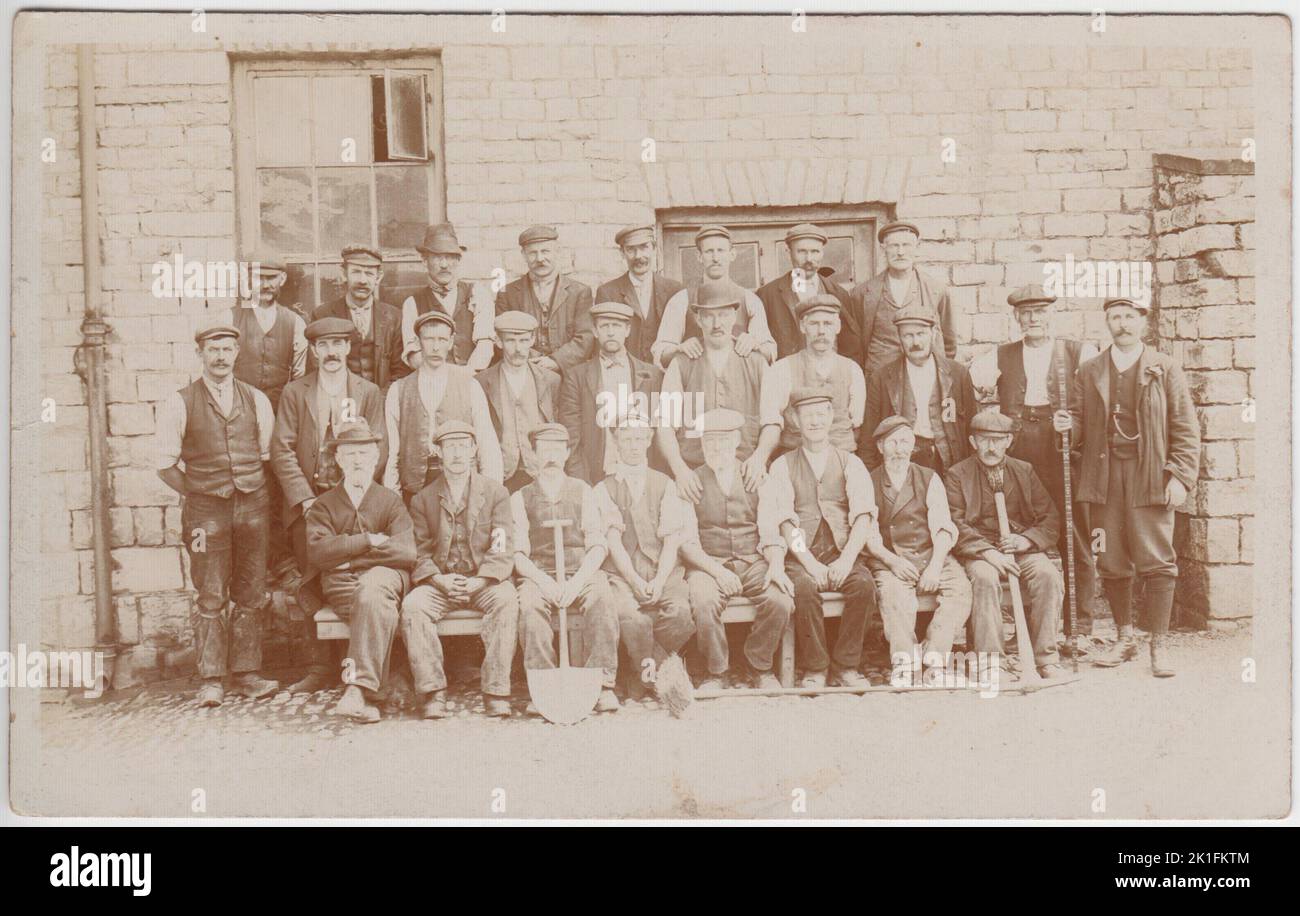 Gruppe von edwardianischen Navvies, fotografiert in Arbeitskleidung (einschließlich einer Reihe an Hüten). Mehrere Männer halten Werkzeuge, darunter einen Spaten und eine Pickaxt Stockfoto