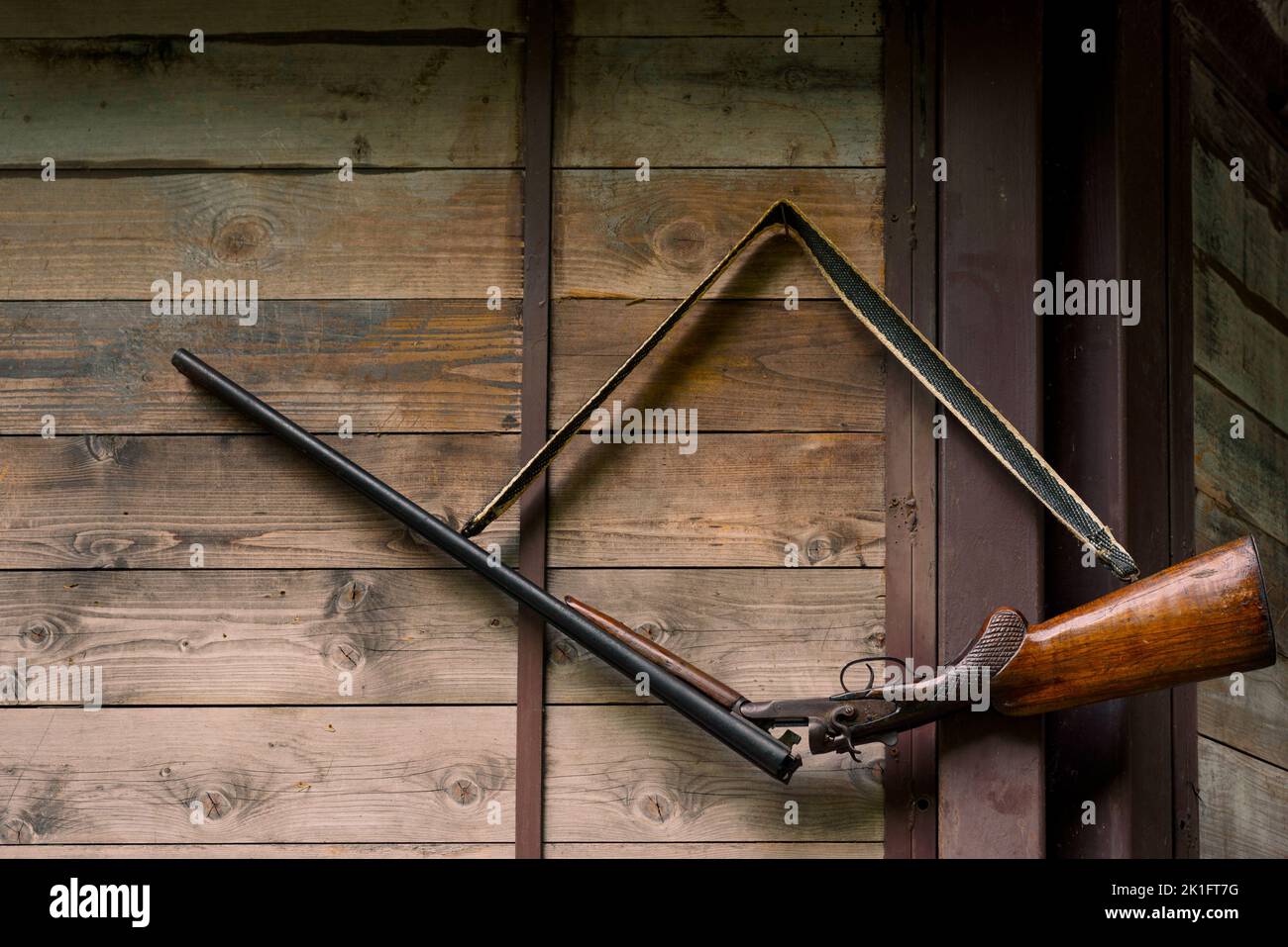 Besitzer Gewehr hängt auf dem Holzzaun in der Landschaft Stockfoto