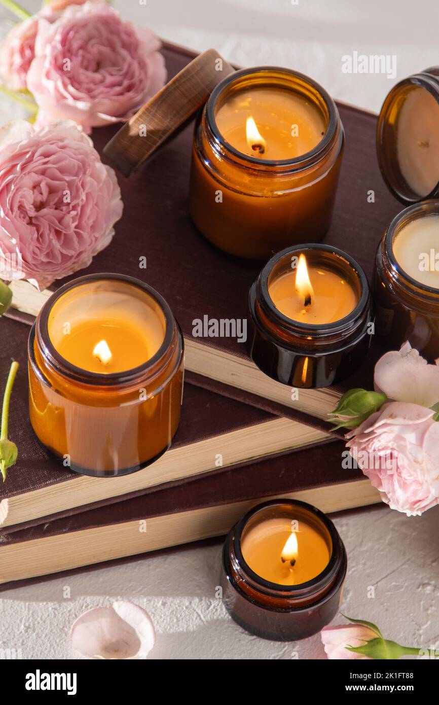 Ein Set verschiedener Duftkerzen in braunen Glasgefäßen. Handgemachte Duftkerze. Sojalkerzen brennen in einem Glas. Aromatherapie und entspannen Sie sich im Spa und zu Hause. Feuer in braunem Glas. Stockfoto