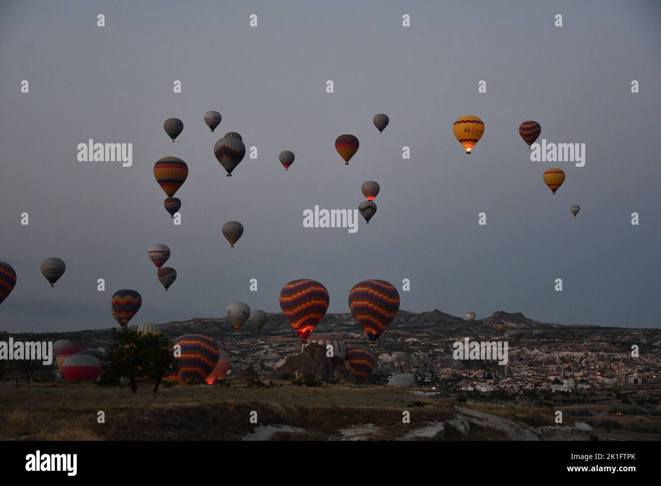 Die unzähligen Heißluftballons in der grauen Morgendämmerung in Kappadokien, Türkei Stockfoto