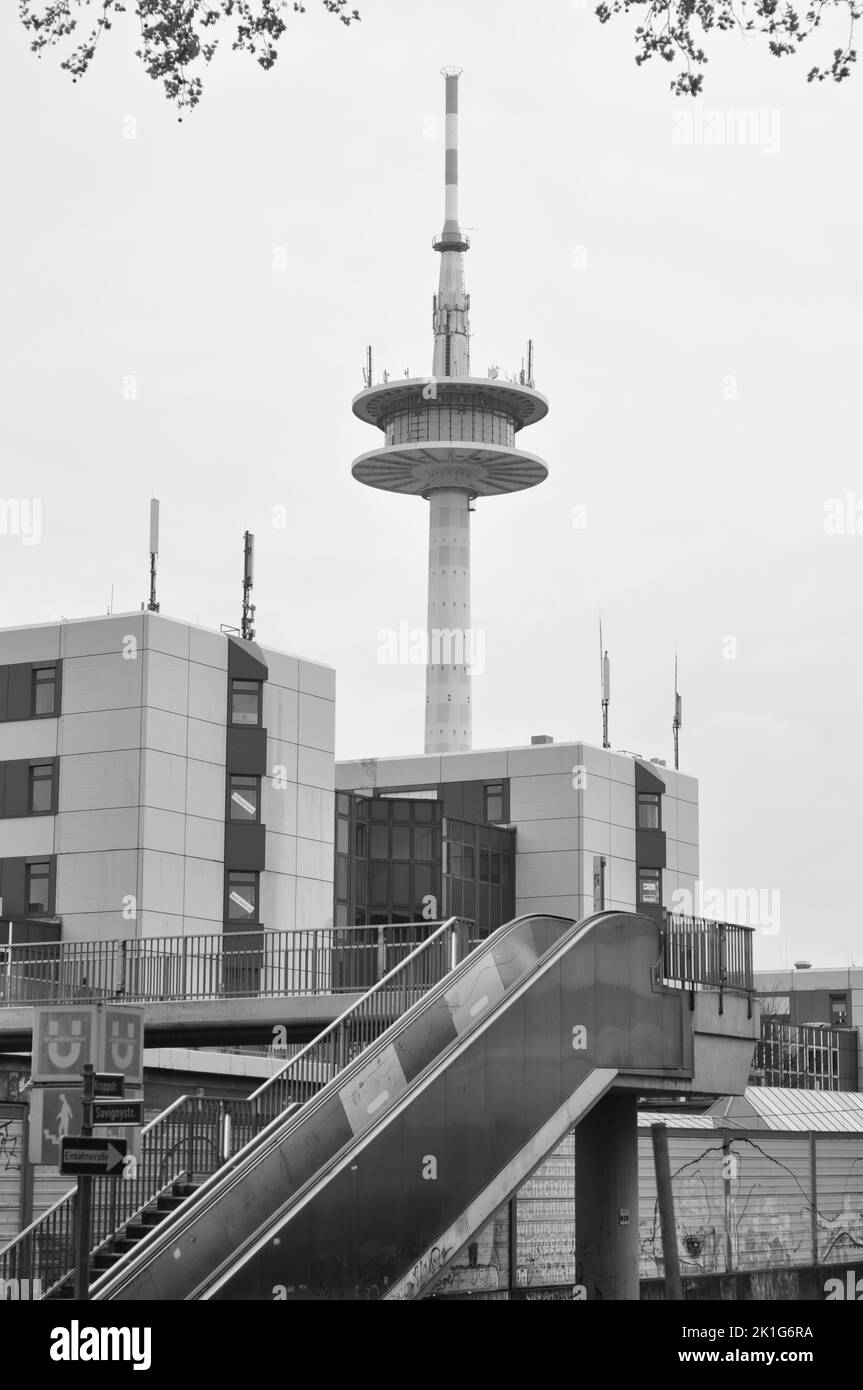 Eine vertikale Graustufenaufnahme eines Fernsehturms und einer Autobahnbrücke auf der A40 in Essen, Deutschland Stockfoto