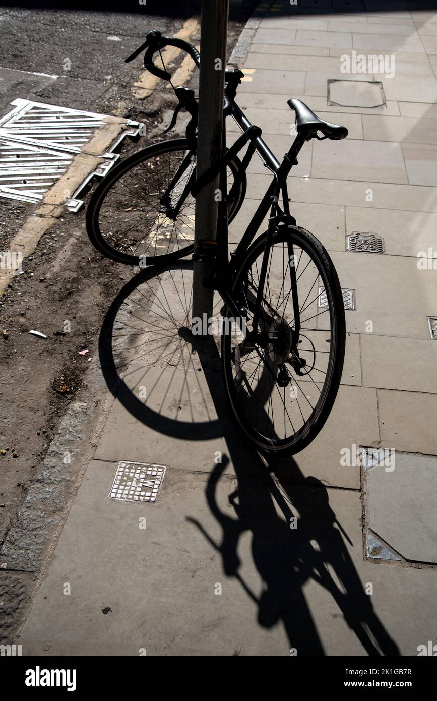 Fahrrad mit Schatten gegen das Licht fotografiert, contre jour, in Edinburgh, Schottland, Großbritannien. Stockfoto
