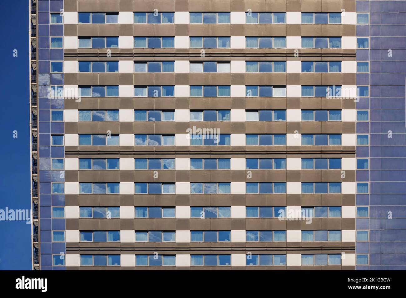 Mehrstöckiges Haus in blauer Farbe mit weißen Fensterrahmen und vielen kleinen Fenstern Stockfoto