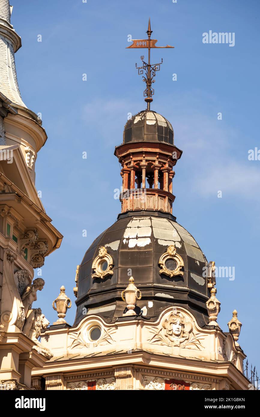 Eine Kirche mit einer braunen Mauer und einer spitzen Metallspitze mitten im Stadtzentrum Stockfoto