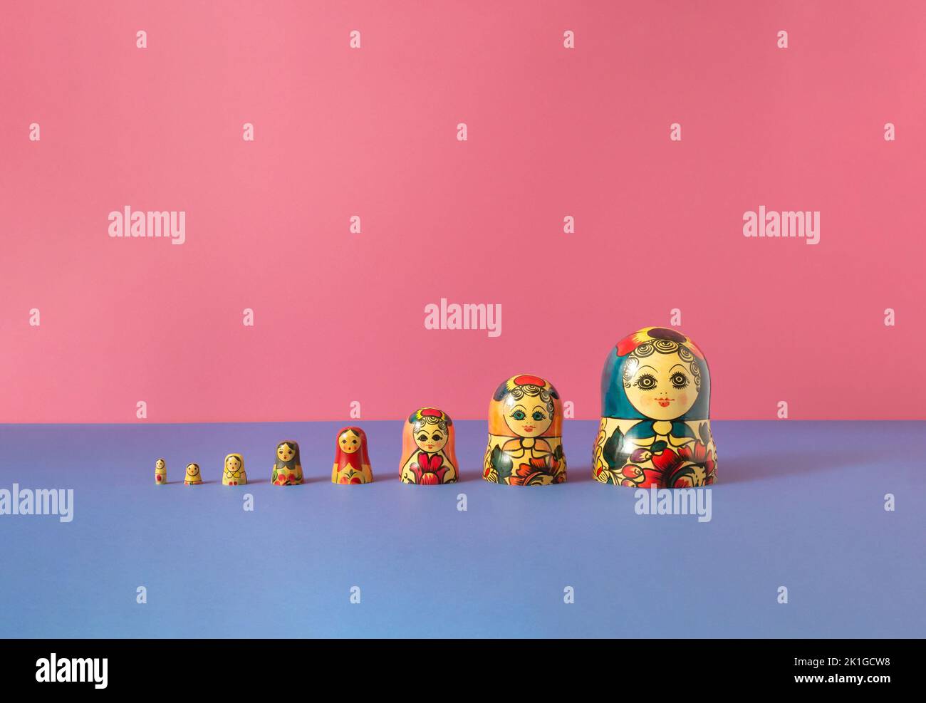 Russische Puppen auch als matryoschka oder babushka auf einem rosa und blauen Hintergrund gestapelt bekannt. Minimalkonzept. Stockfoto