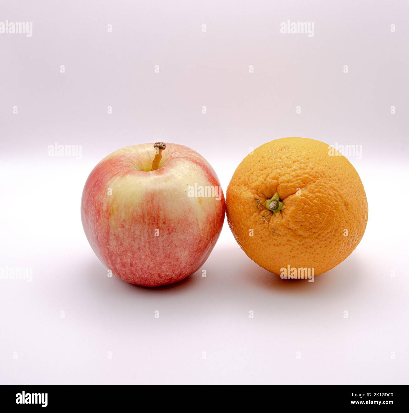 Nahaufnahme eines königlichen Gala-Apfels und einer Orange vor weißem Hintergrund Stockfoto