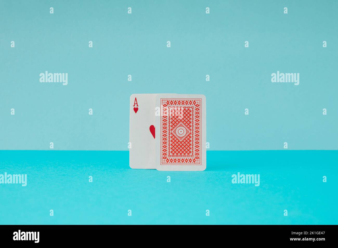 Zwei Spielkarten mit Herz-Ass auf blauem Hintergrund. Minimalkonzept. Stockfoto