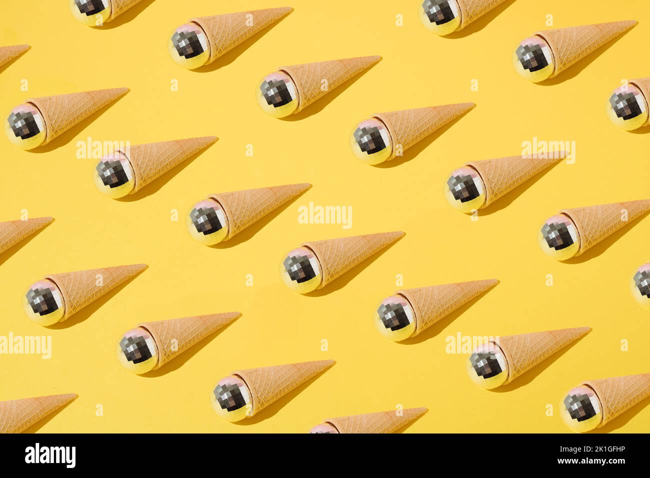 Sommermuster mit Eiszapfen und Diskokugeln auf gelbem Hintergrund. Minimalkonzept. Stockfoto