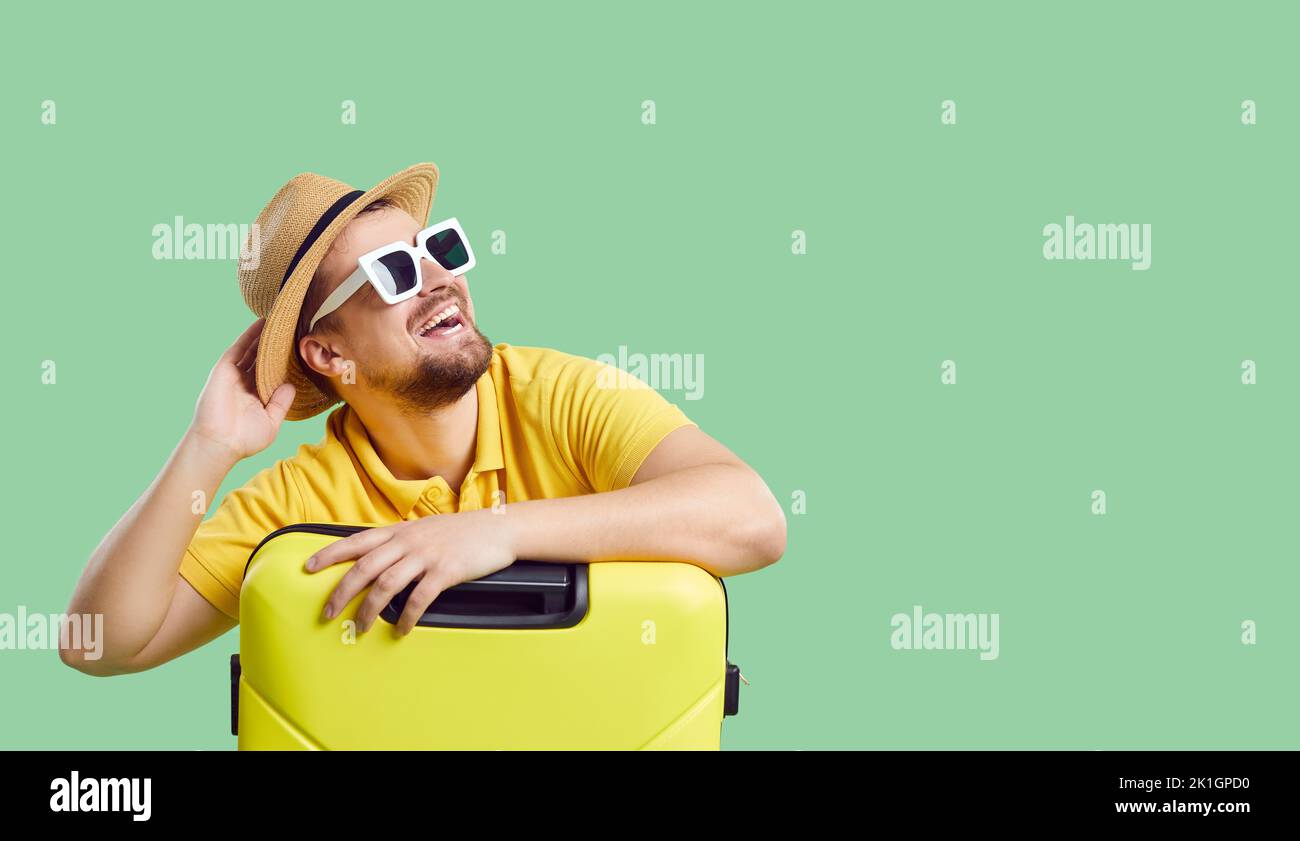 Lächelnder Mann mit Koffer träumt von Sommerferien Stockfoto