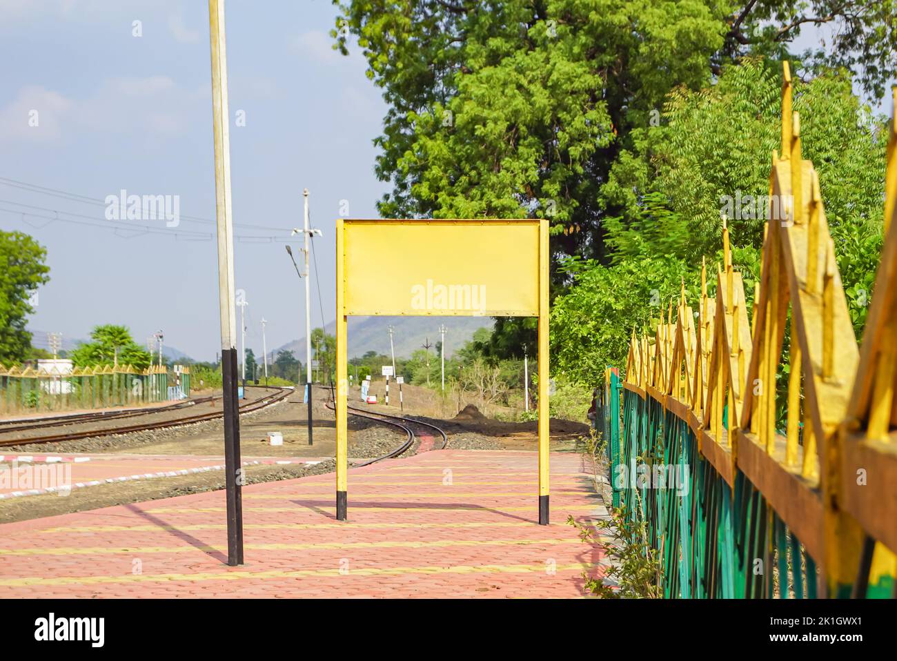 An einem sonnigen Sommertag ist ein leeres Bahnschild am Bahnhofssteig eines indischen Bergdorfes zu sehen. Indianerdorf. Stockfoto