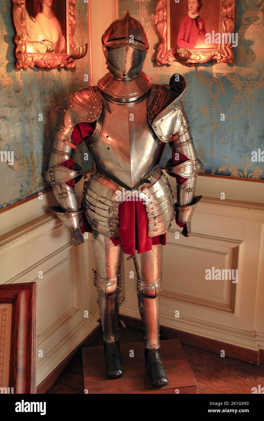 Ein Schuss eines glänzenden Anzugs aus mittelalterlicher Ritterrüstung gegen die verzierten Palastmauern Stockfoto