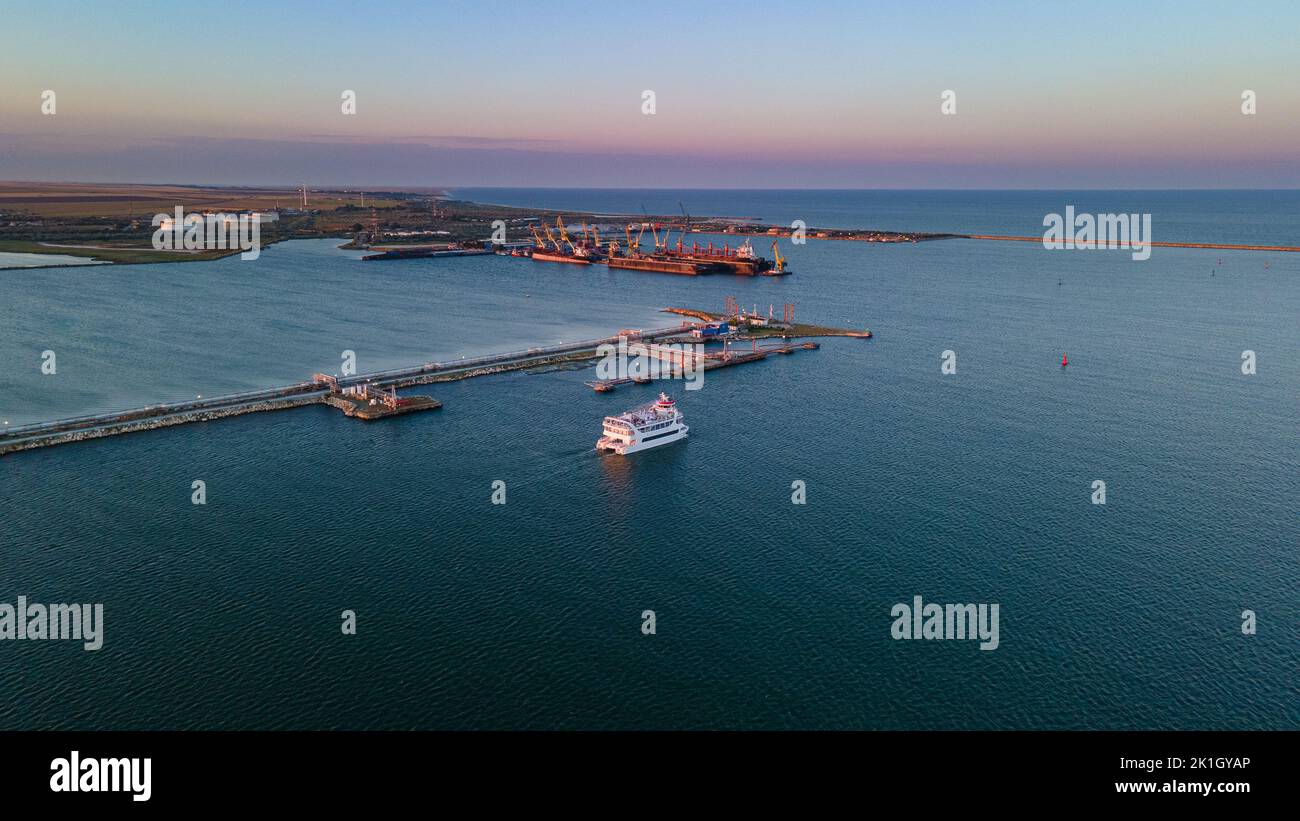 Luftaufnahme eines Hafens mit Schiffen, die segeln und andocken. Die Fotografie wurde von einer Drohne in einer höheren Höhe in der Sommersaison bei Sonnenuntergang aufgenommen. Stockfoto