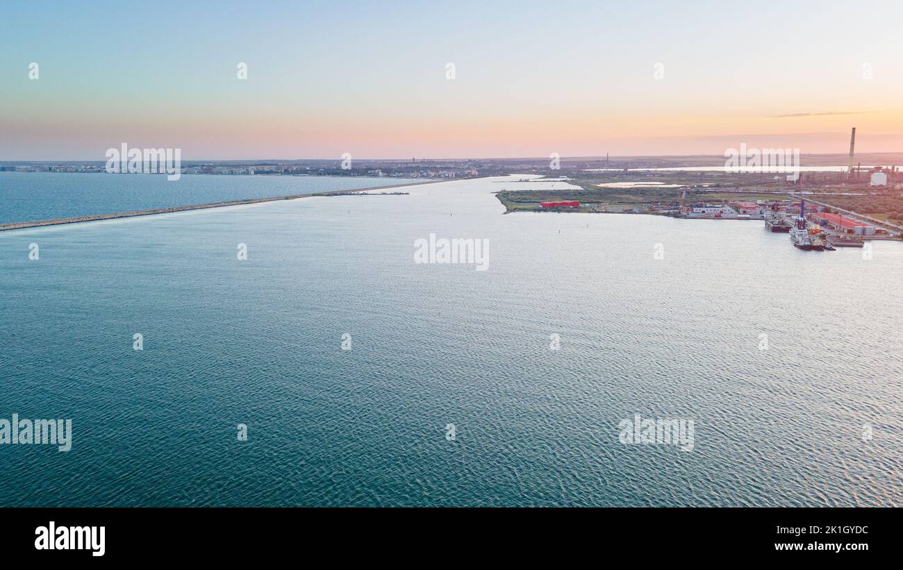 Luftaufnahme eines Hafens mit Schiffen, die segeln und andocken. Die Fotografie wurde von einer Drohne in einer höheren Höhe in der Sommersaison bei Sonnenuntergang aufgenommen. Stockfoto