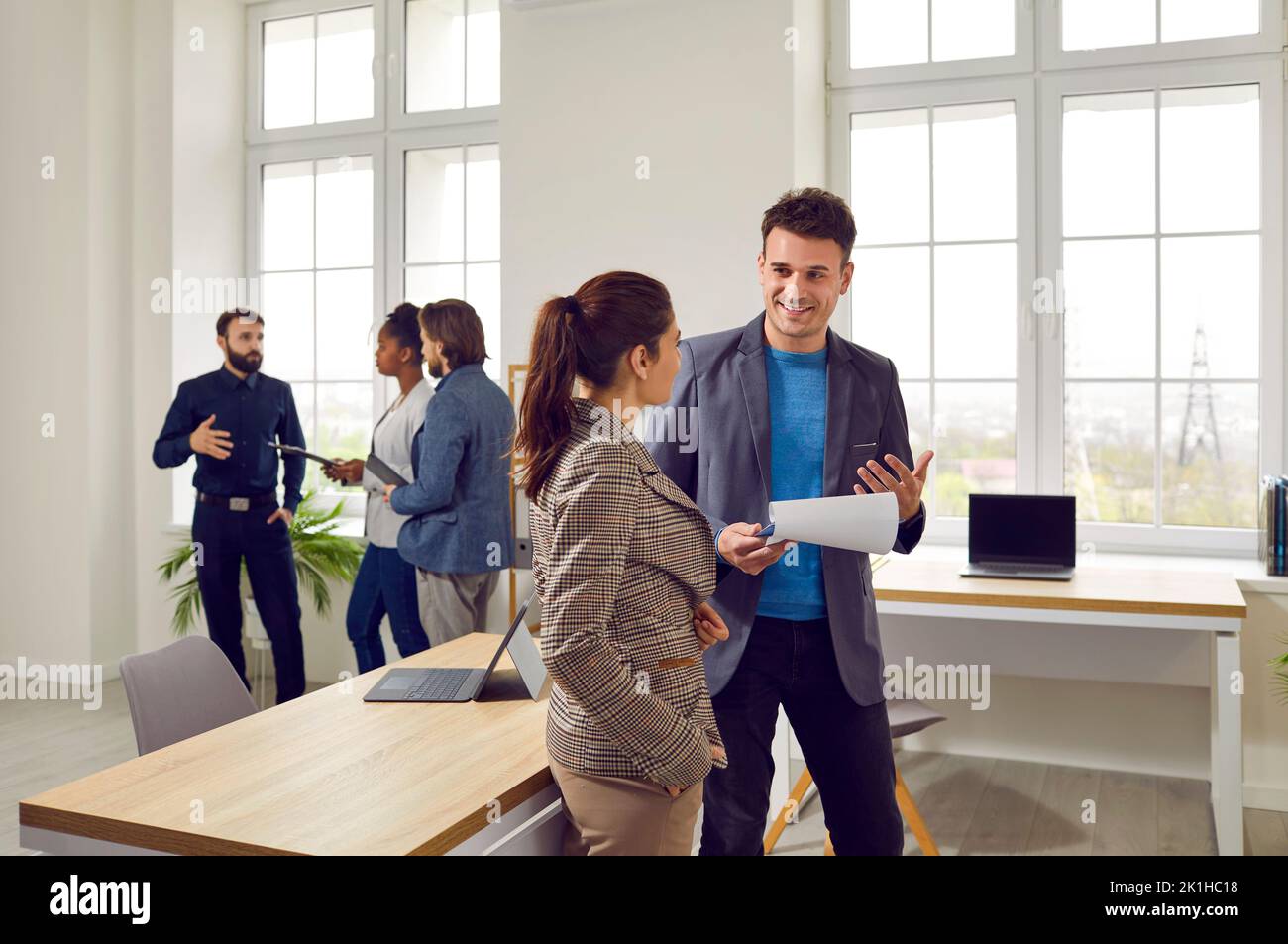 Zwei Business-Kollegen unterhalten sich freundlich über die Arbeit im Coworking-Büro. Stockfoto