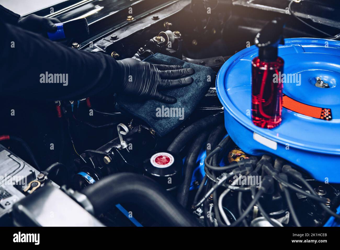 Automechaniker oder Autowascharbeiter reinigen den Automotor mit einem Tuch. Stockfoto