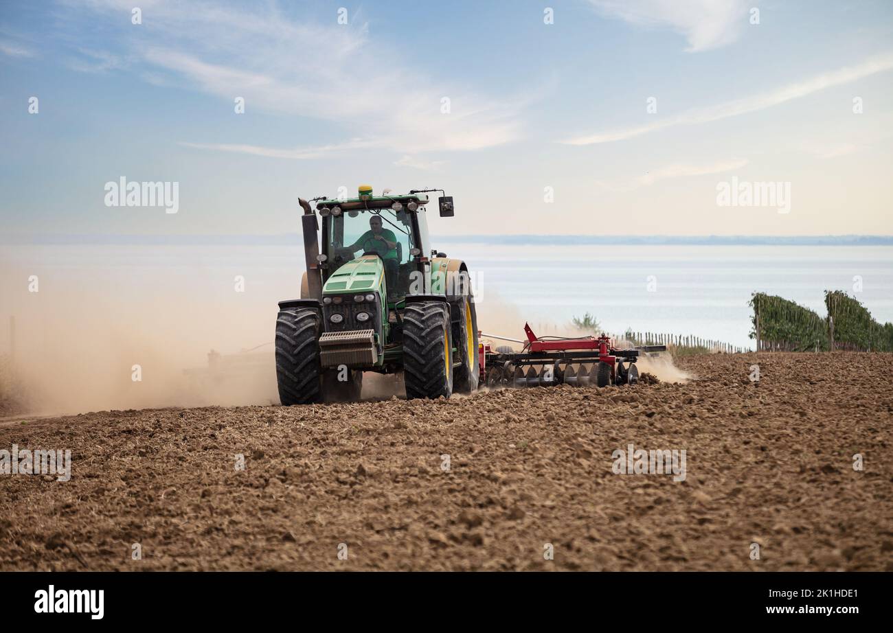 Cherson Oblast (Provinz), Ukraine - 26. August 2021: Landwirt in Traktor arbeiten auf dem Feld am Sommertag Stockfoto