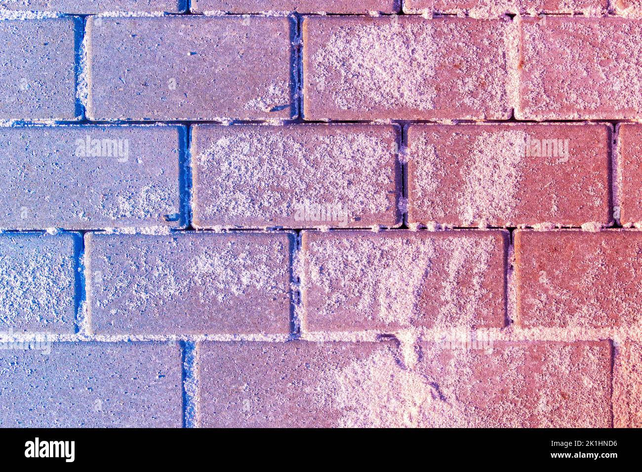 Blauer bis roter Gradient überlagert auf sandbestreuten Pflasterplatten, selektiver Fokus Stockfoto