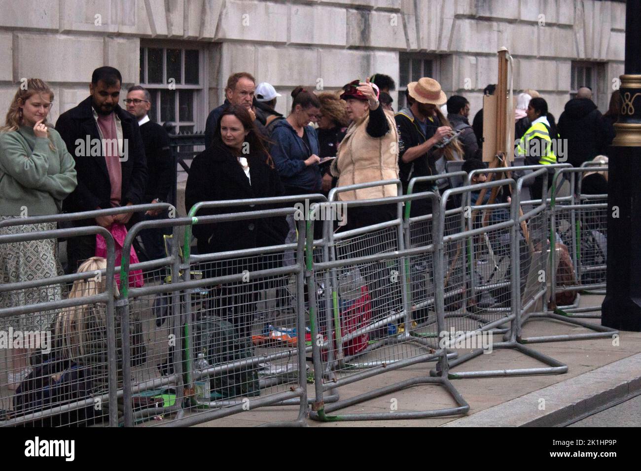 Ein Künstler, der in der Nacht vor dem Begräbnis der Königin an einer Staffelei unter der Schlange von Menschen auf dem Bürgersteig in Whitehall, London, Großbritannien, malte Stockfoto