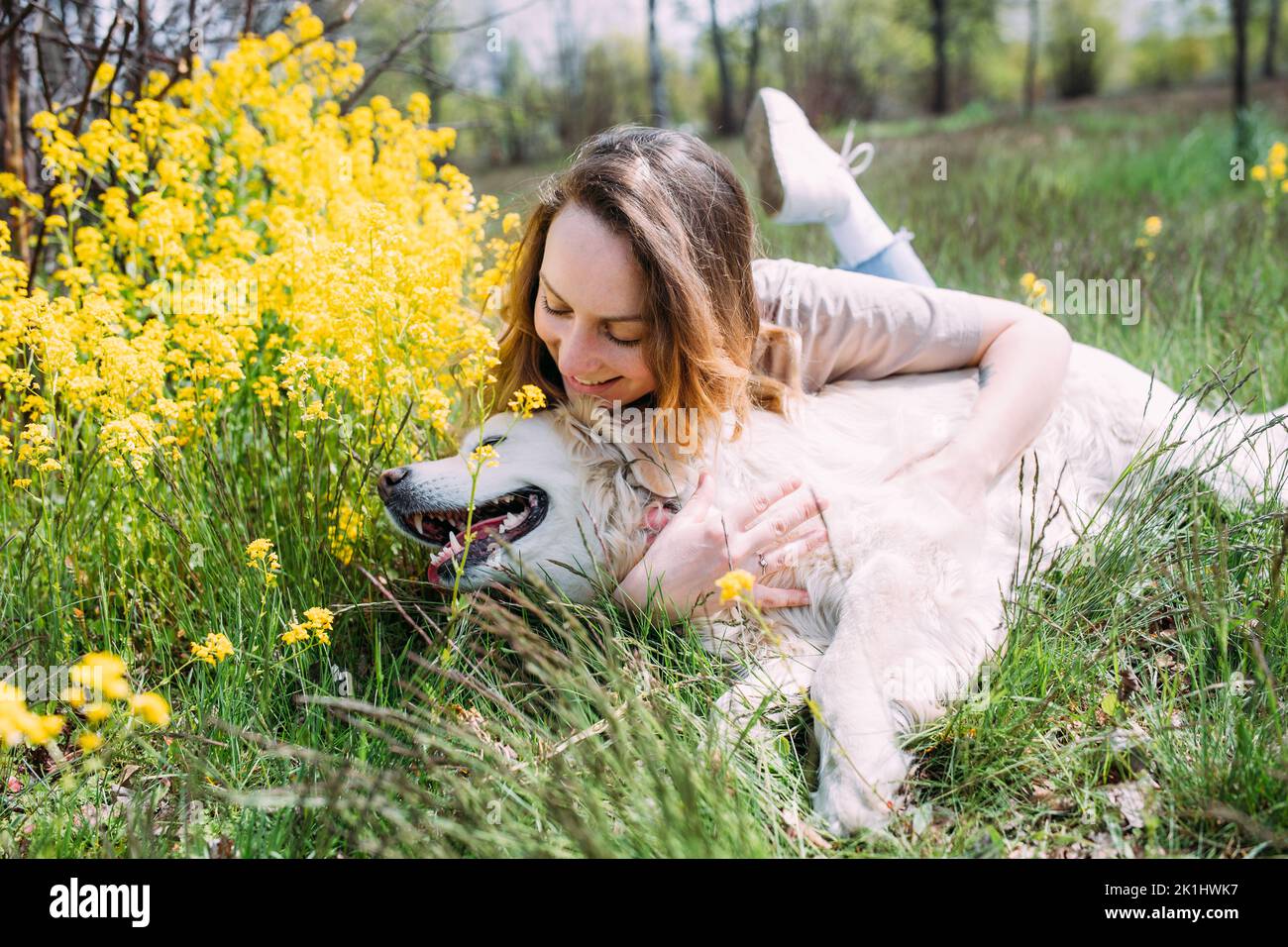Junge schöne Frau und ihr goldener Retriever Hund haben Spaß im Sommer Stockfoto