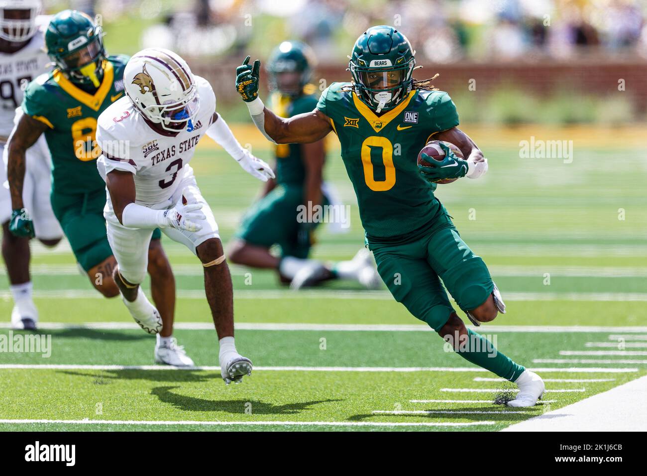 Baylor Bears läuft zurück Craig Williams (0) geht vor dem Texas State Bobcat-Eckpfeiler Kordell Rodgers (3) für einen 30-Yard-Touchdown-Lauf mit noch 11:45 in Stockfoto