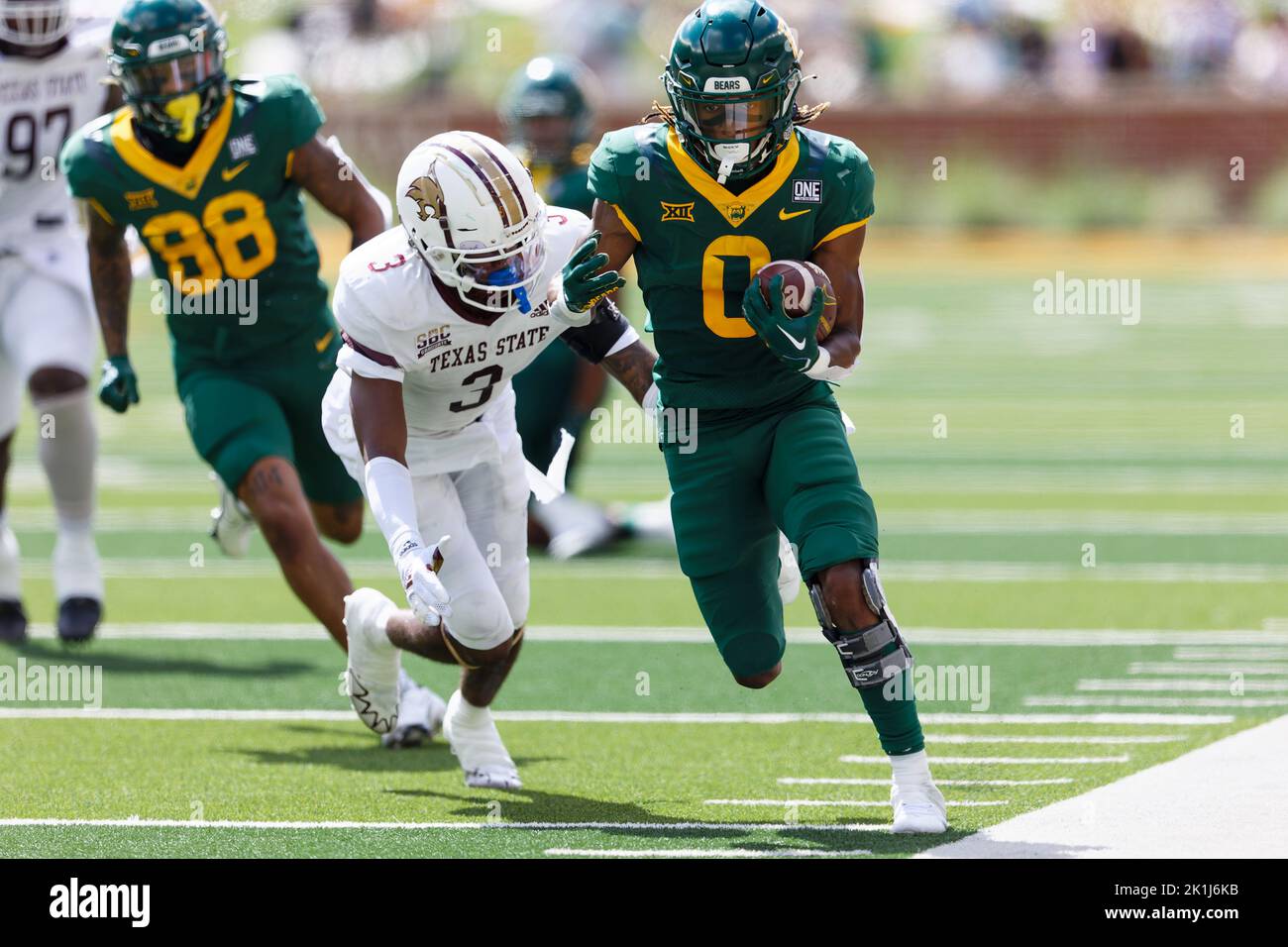 Baylor Bears läuft zurück Craig Williams (0) geht vor dem Texas State Bobcat-Eckpfeiler Kordell Rodgers (3) für einen 30-Yard-Touchdown-Lauf mit noch 11:45 in Stockfoto
