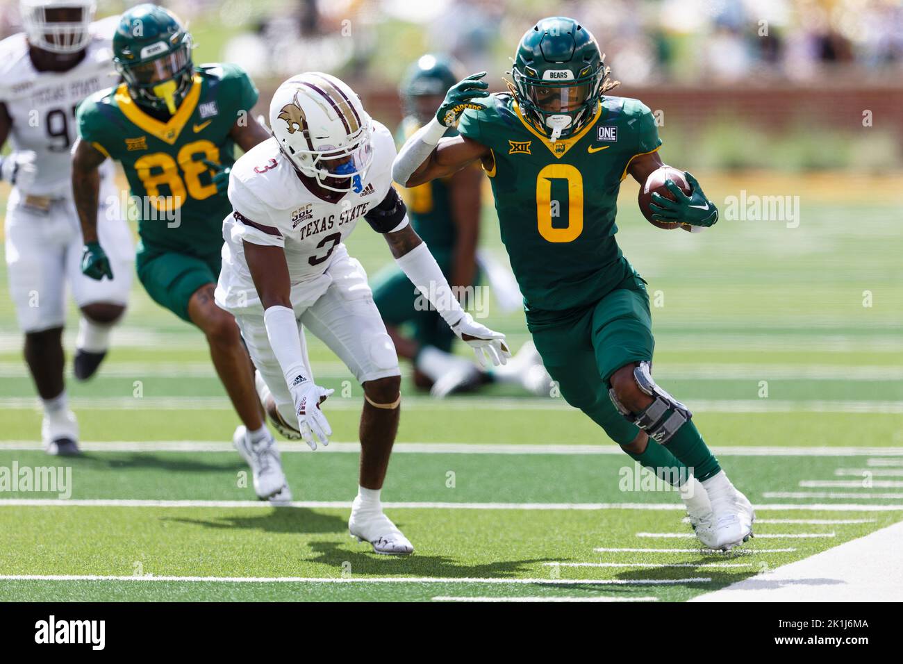 Baylor Bears läuft zurück Craig Williams (0) geht vor dem Texas State Bobcat-Eckpfeiler Kordell Rodgers (3) für einen 30-Yard-Touchdown-Lauf mit noch 11:45 in Stockfoto